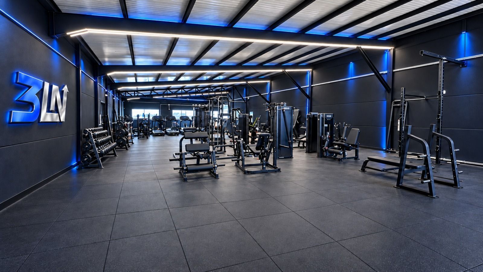 Interior moderno de gimnasio con equipamiento negro, iluminación azul y un gran logotipo de 3M en la pared