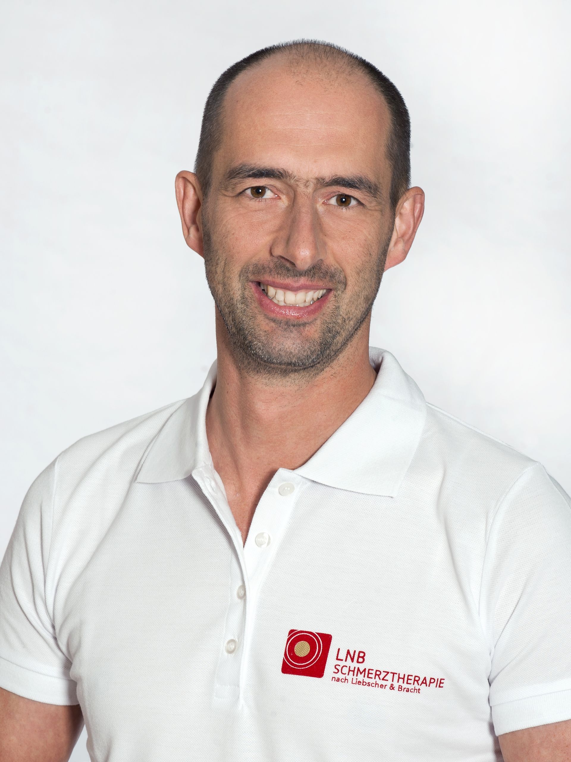 Robert Haimerl in einem weißen Poloshirt vor hellem Hintergrund