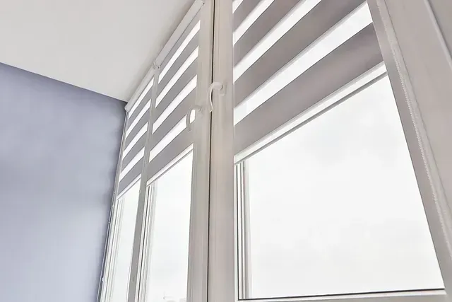 Un primer plano de una ventana con contraventanas blancas en una habitación.