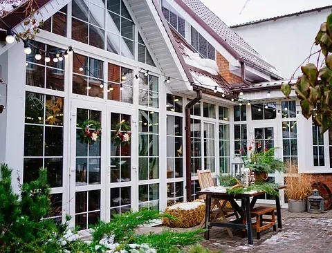 Una gran casa blanca con muchas ventanas y una mesa delante de ella.