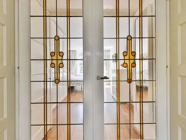 Un par de puertas de vidrieras que conducen a una sala de estar.