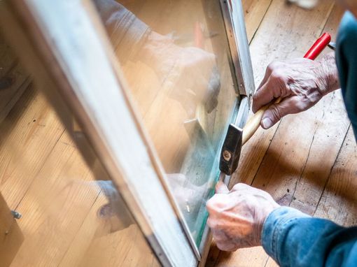 Una persona está cortando una ventana con un par de tijeras.