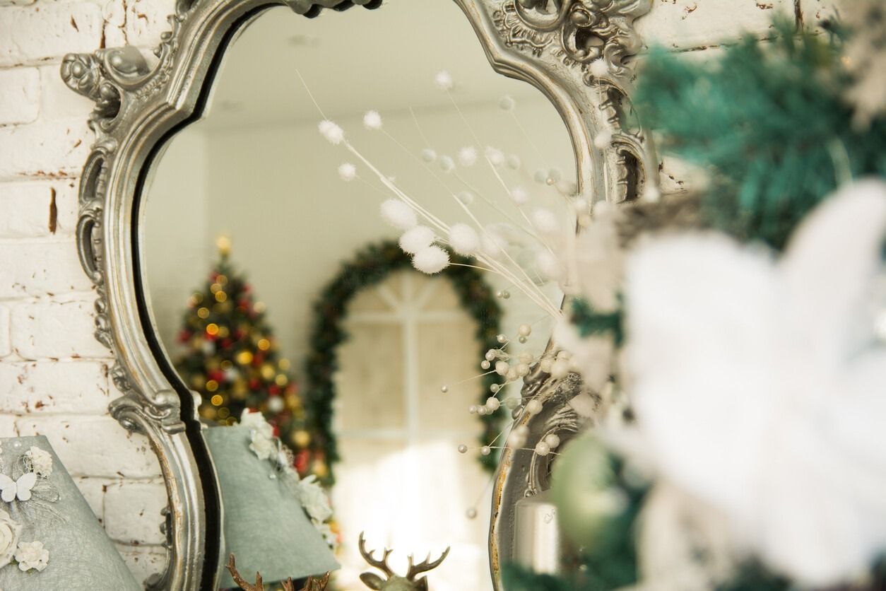 Un espejo con un árbol de Navidad reflejado en él.