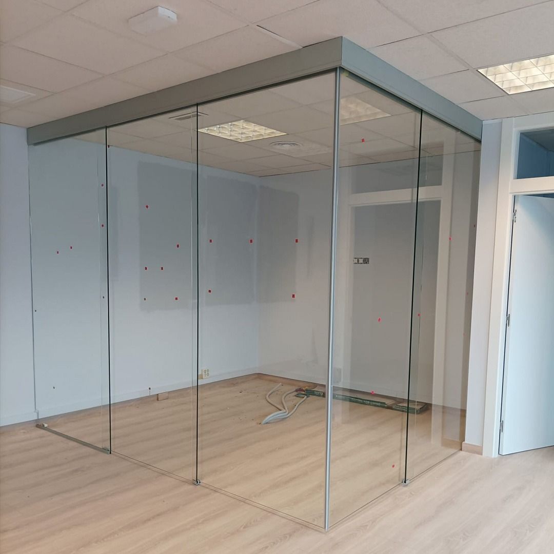 Una habitación con muchas paredes de cristal y suelo de madera.