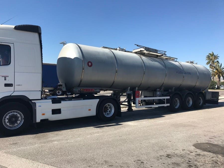 Un gran camión cisterna está estacionado al costado de la carretera.