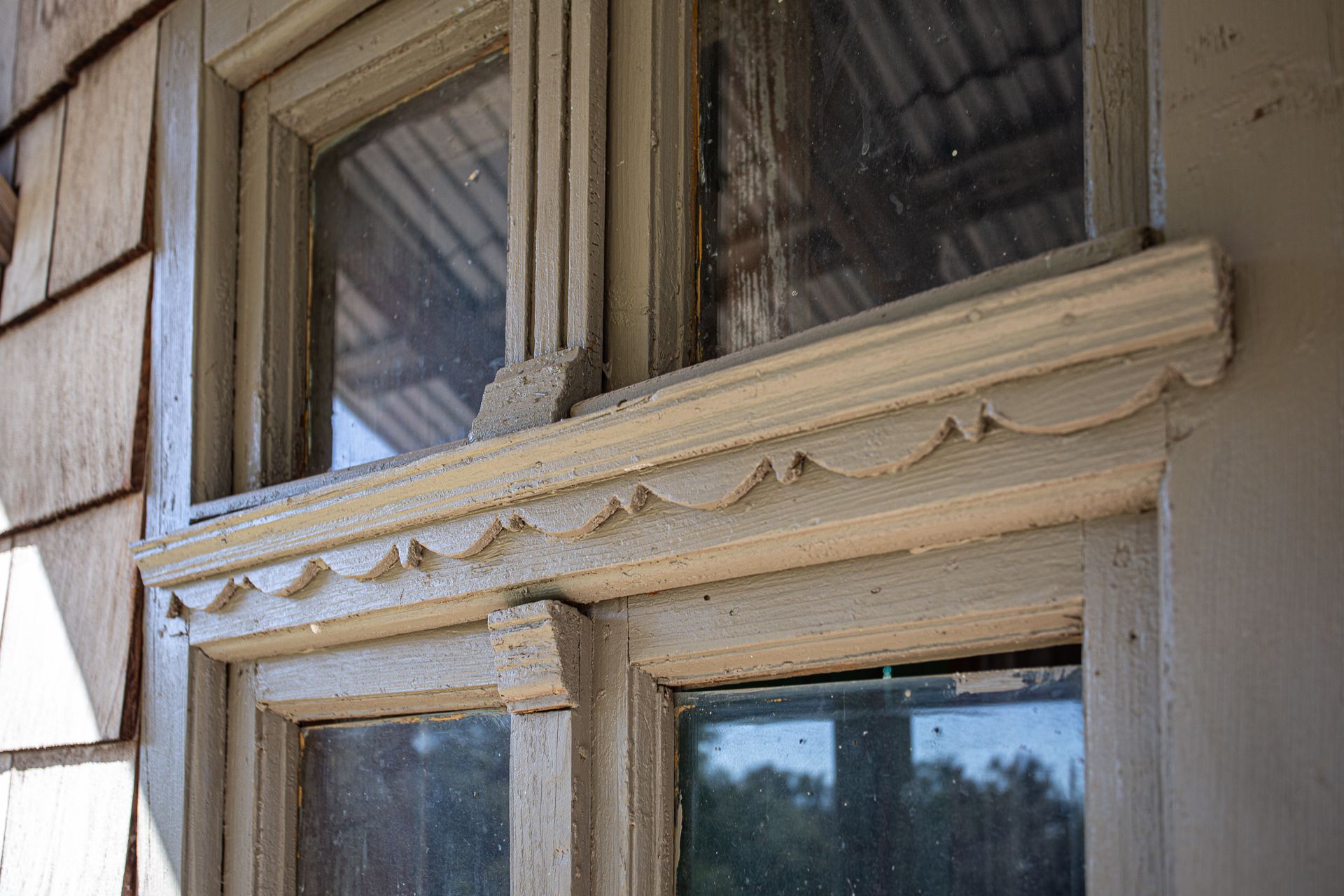 A close up of a window with a wooden trim on a building.