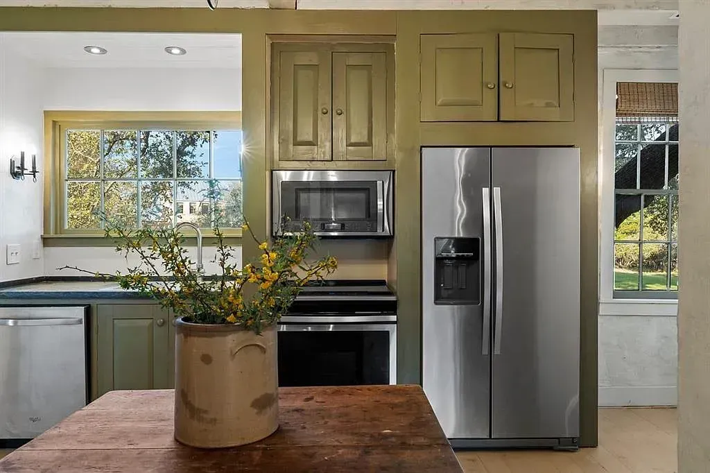 A kitchen with a stainless steel refrigerator and microwave