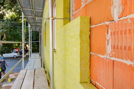 Un mur de briques avec une isolation jaune en cours d'installation.