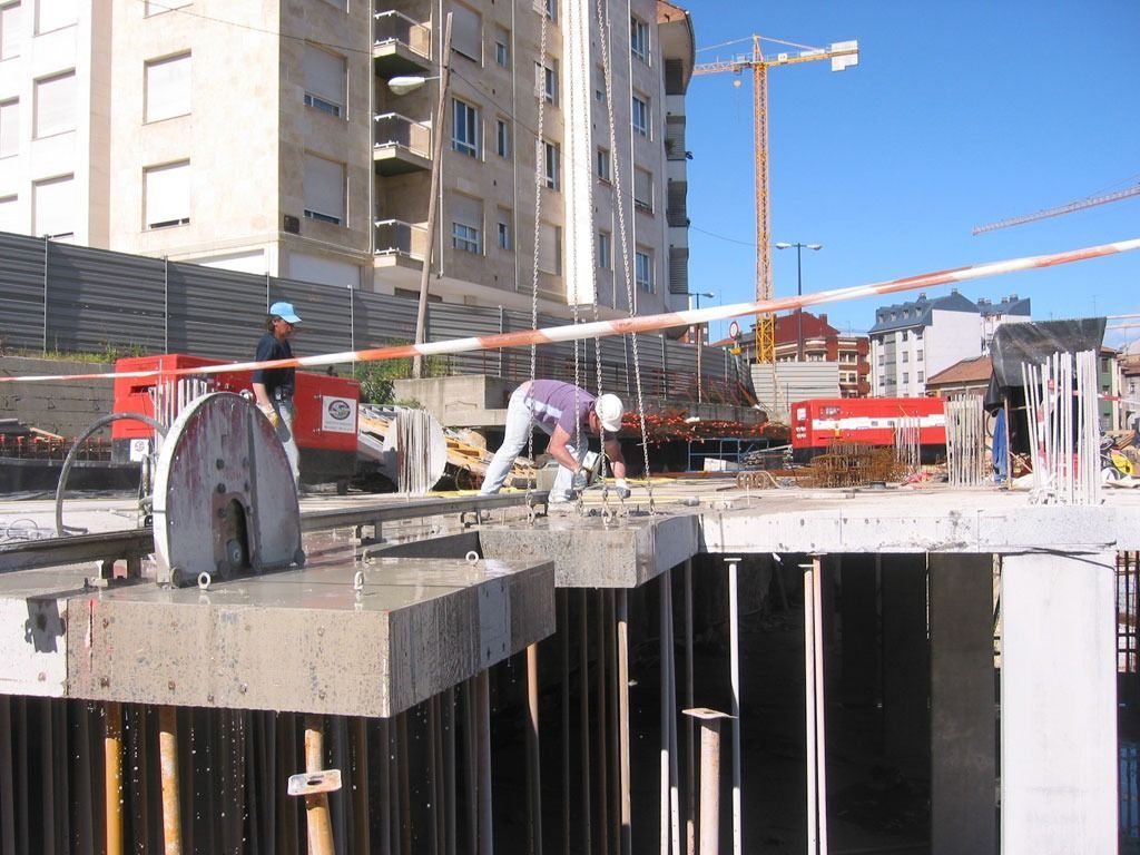 Un sitio de construcción con una grúa al fondo