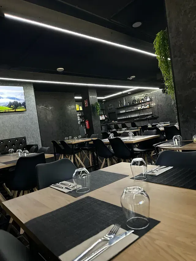 Un restaurante con mesas y sillas preparadas para comer.