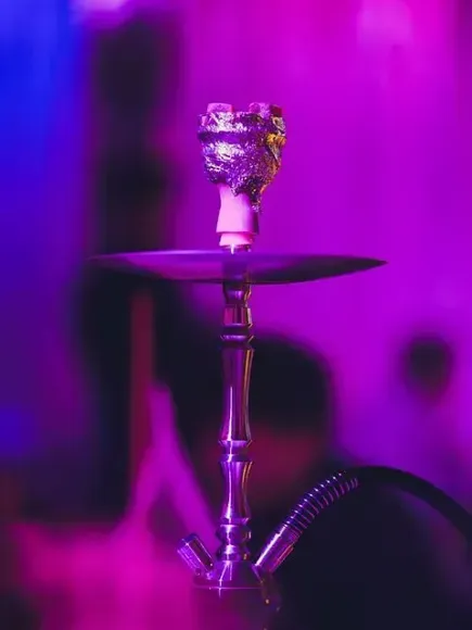 Un primer plano de una cachimba con un fondo morado.