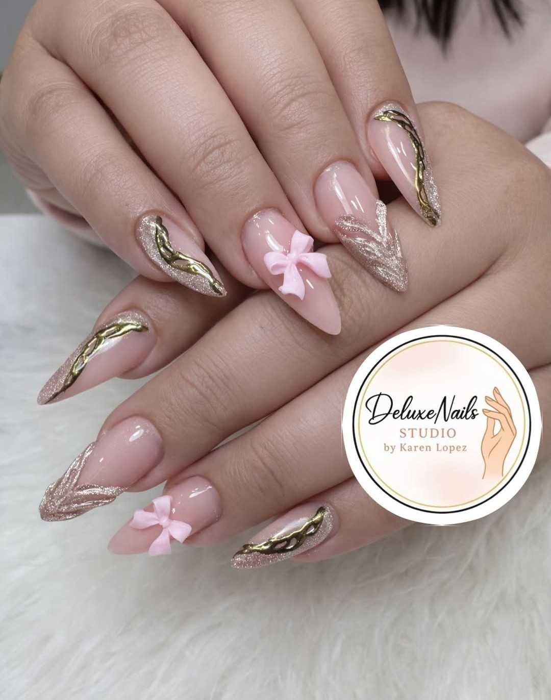 Manos con uñas de aguja color nude y con purpurina dorada, y detalles de lazos rosas en 3D.