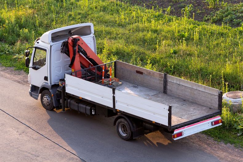 Camion-grue avec un espace de stockage à l'arrière.