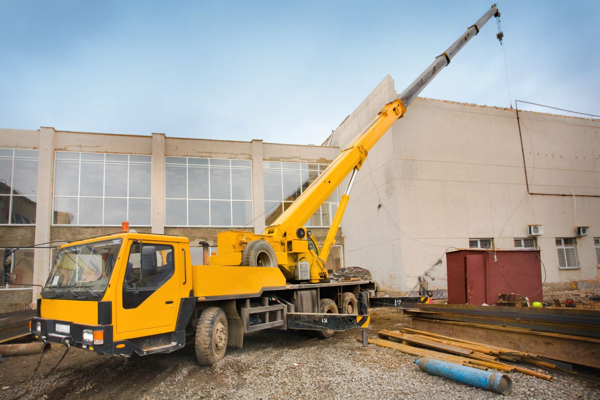 Un camion jaune de levage par bras hydraulique.