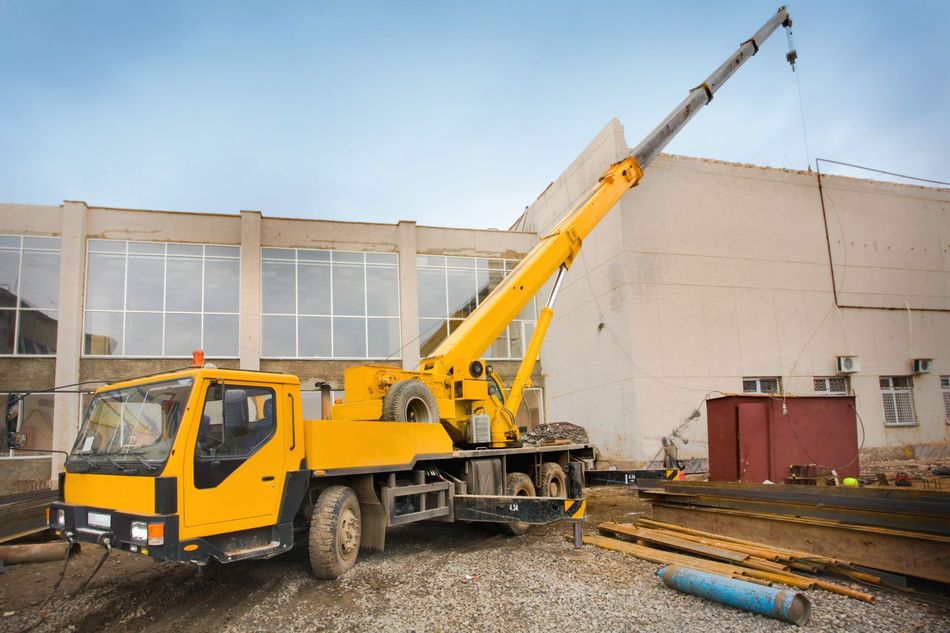 Un camion jaune de levage par bras hydraulique.