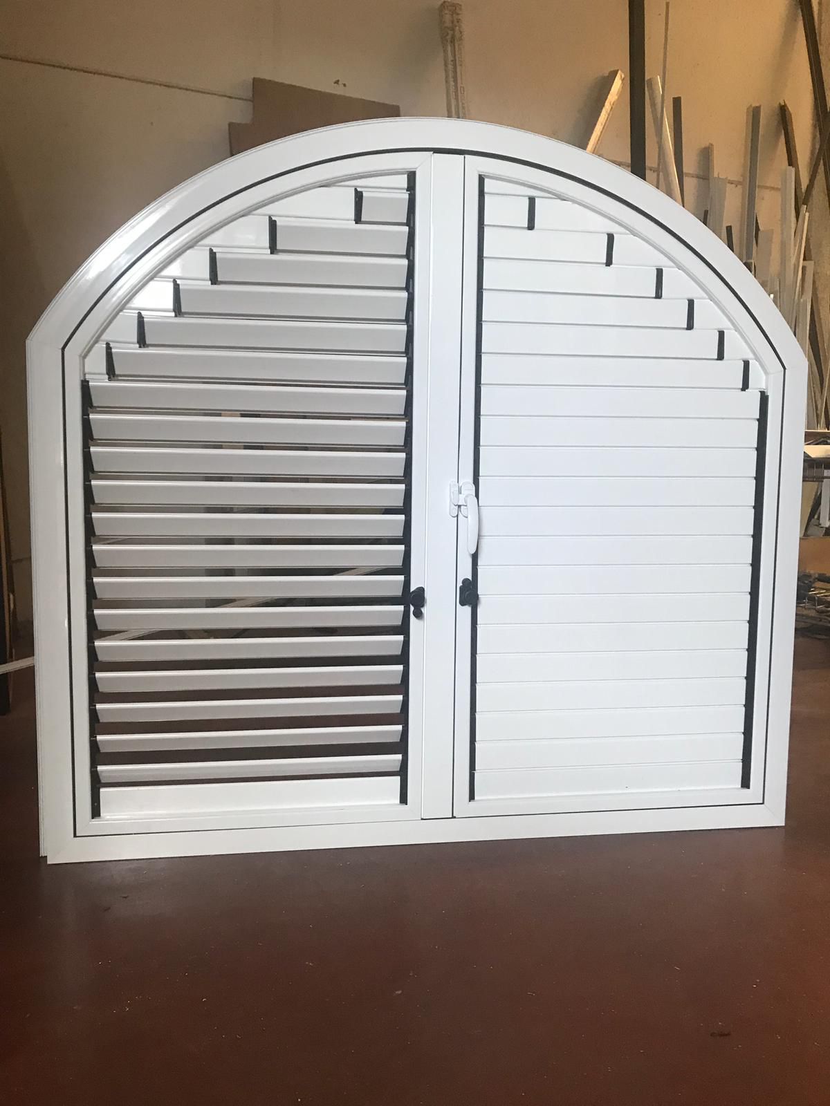 Una ventana con mosquitera está en una pared de ladrillos.