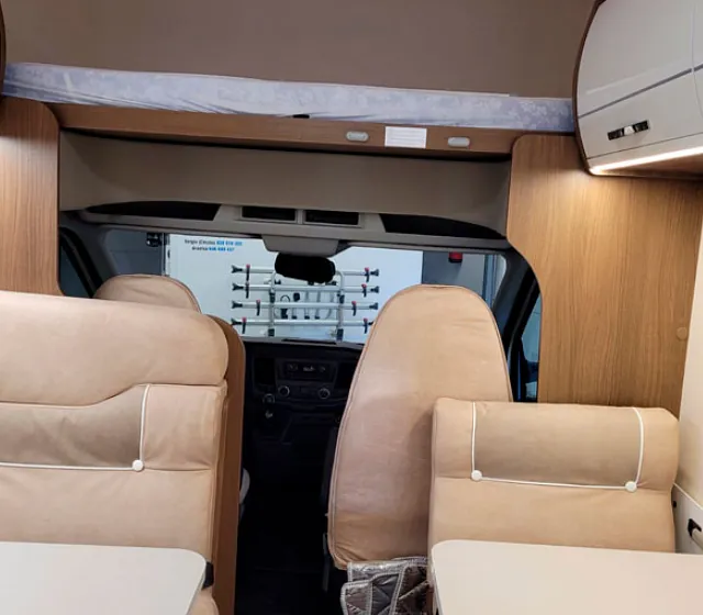 El interior de una caravana con mesa y sillas.