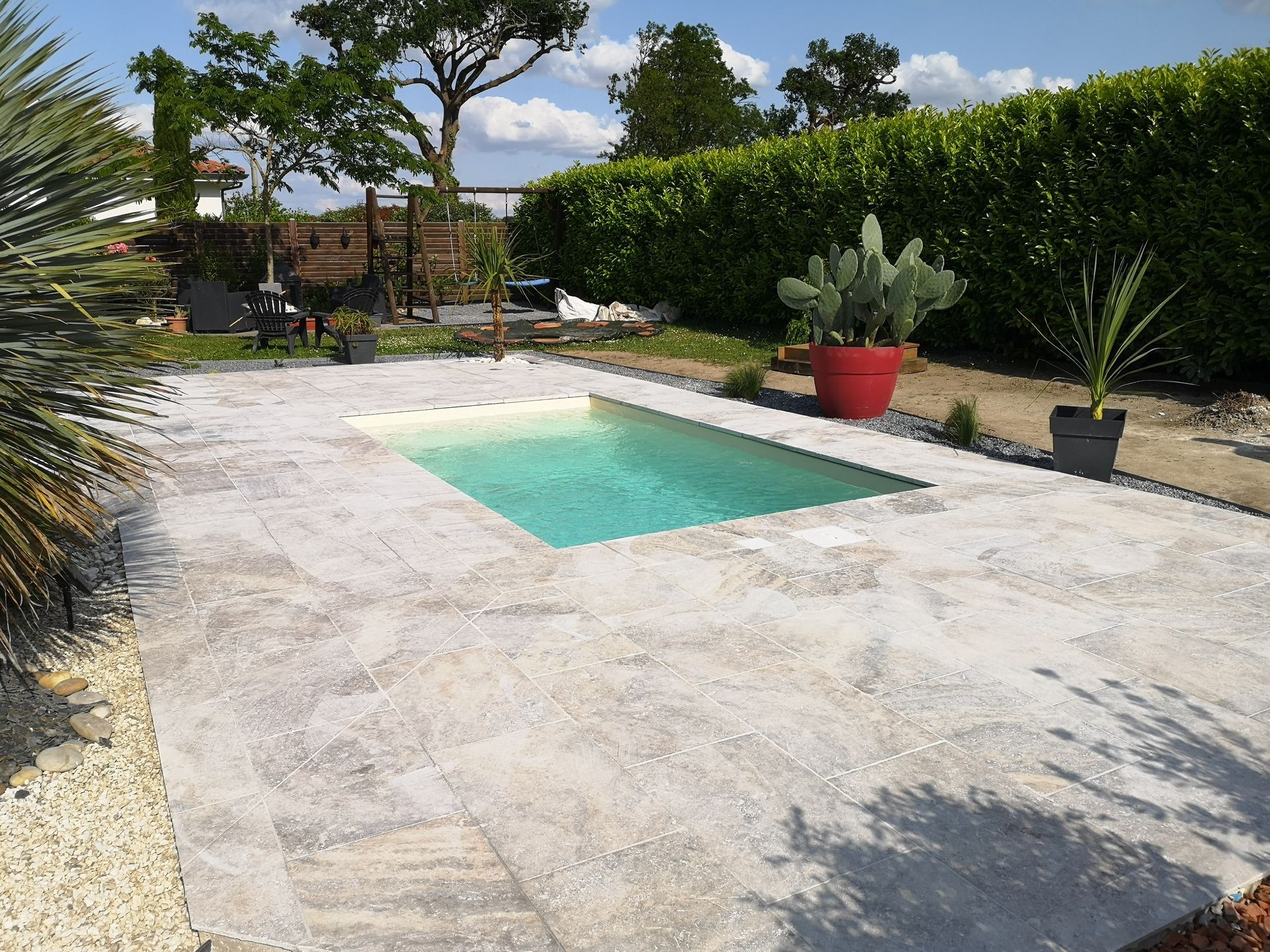 Petite piscine rectangulaire avec sol pavé atour offrant une finition élégante à l'ensemble