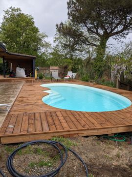 Piscine aux formes arrondies et sol en bois