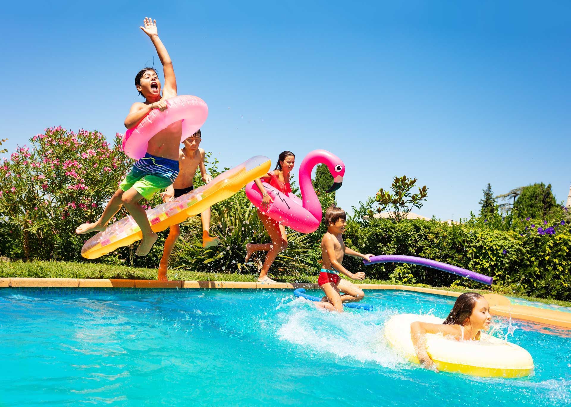 Des enfants sautant dans une piscine