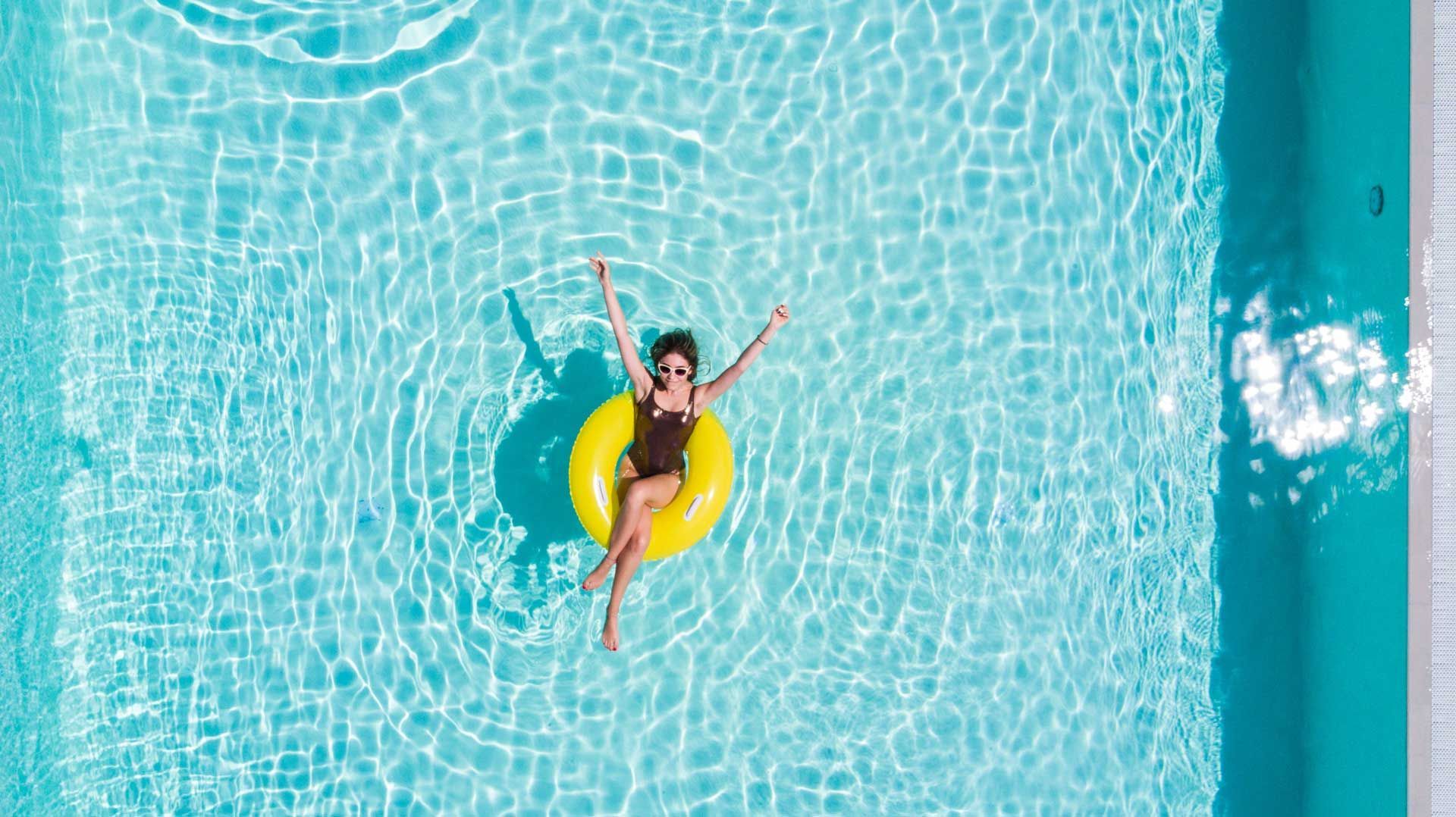 Une femme dans une bouée gonflable au milieu d'une piscine