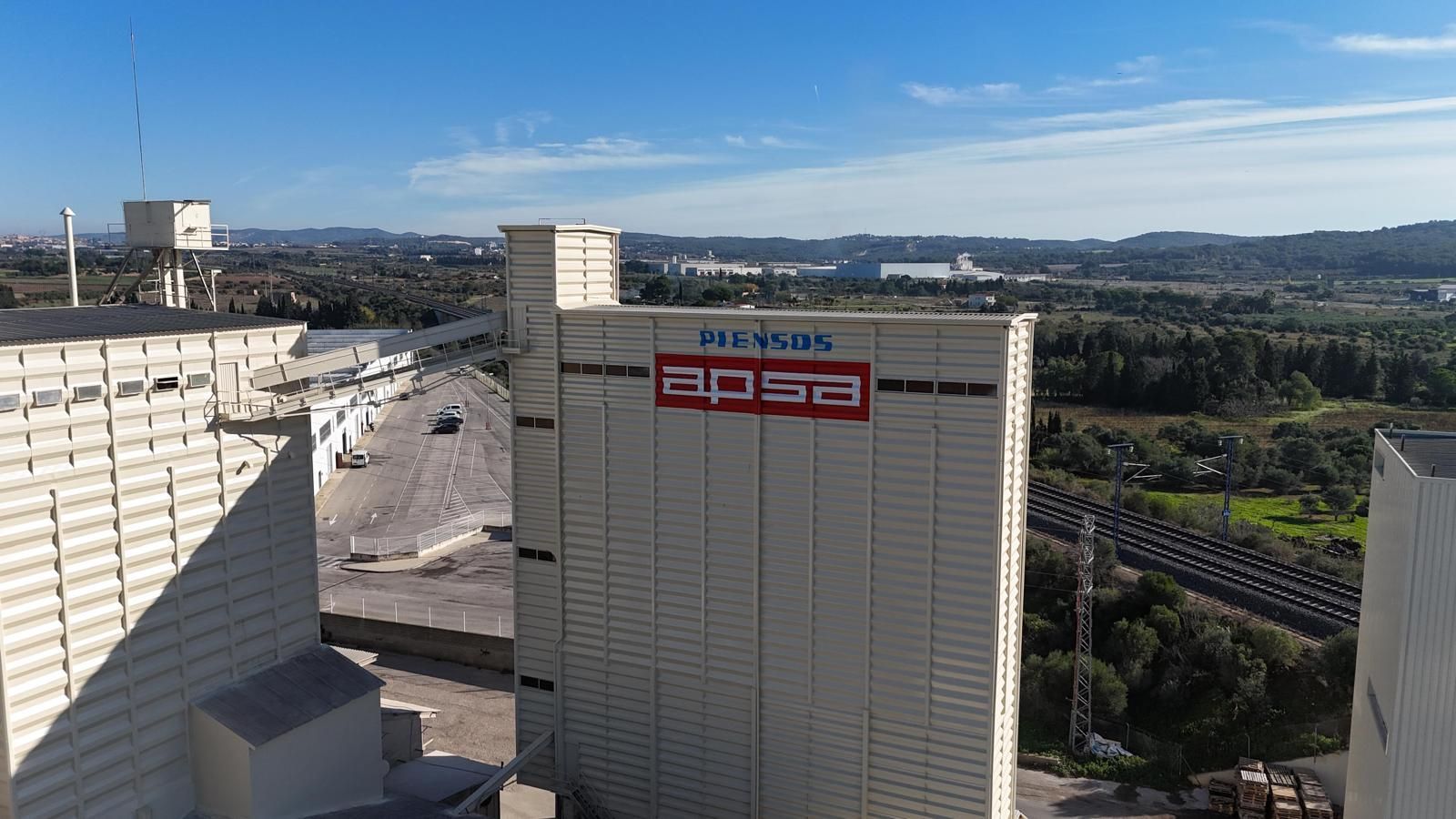 Gran silo industrial de APSA bajo un cielo azul; el edificio es de color beige con el logotipo rojo.