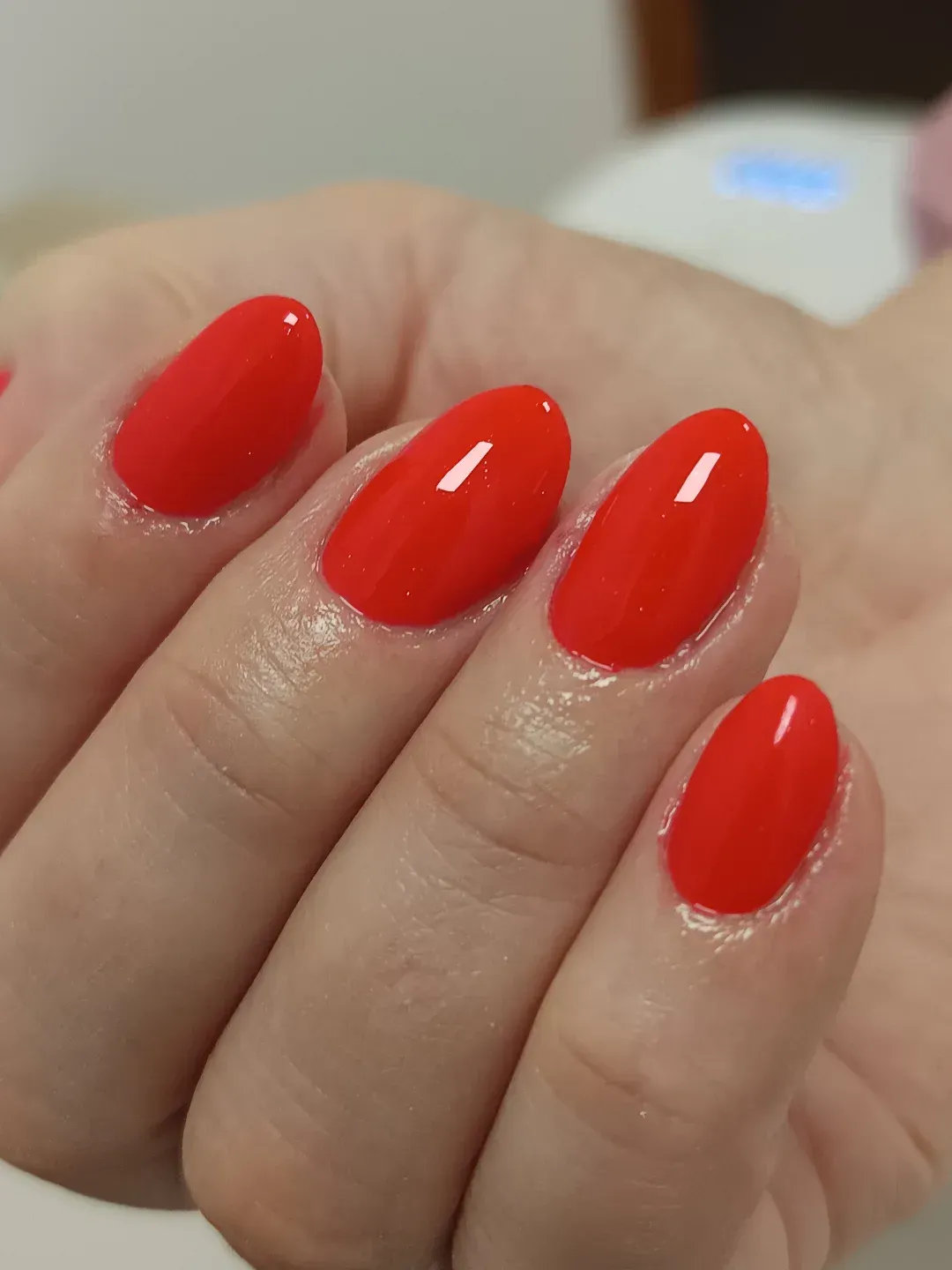 Mano con uñas pintadas de un rojo brillante y bien cuidadas, vista de cerca.