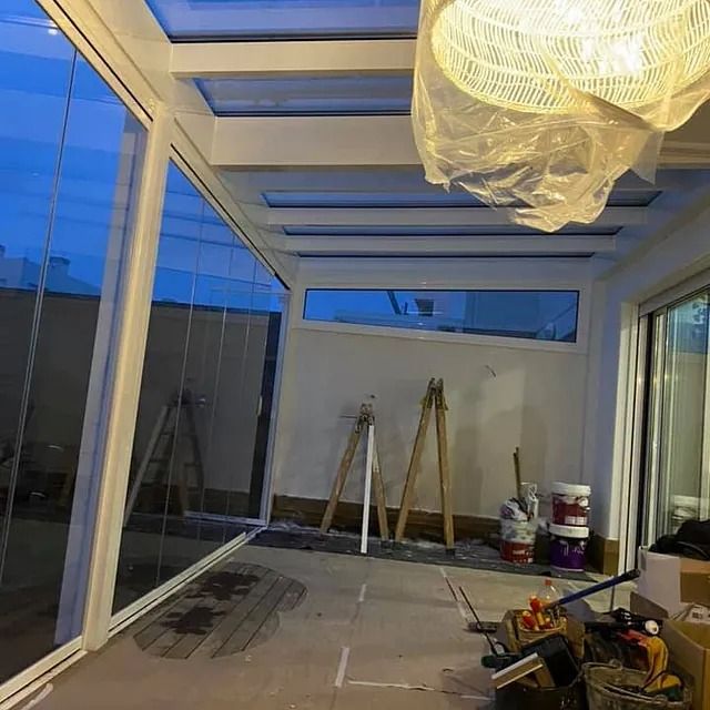 Una habitación con muchas ventanas y una luz colgando del techo.