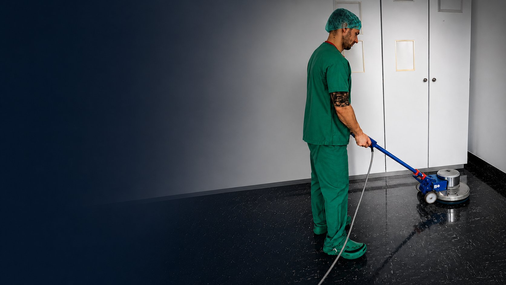 Ein Arbeiter saugt in einem Renovierungsraum mit einem Industriesauger Staub auf, während auf dem Boden Schutt liegt.
