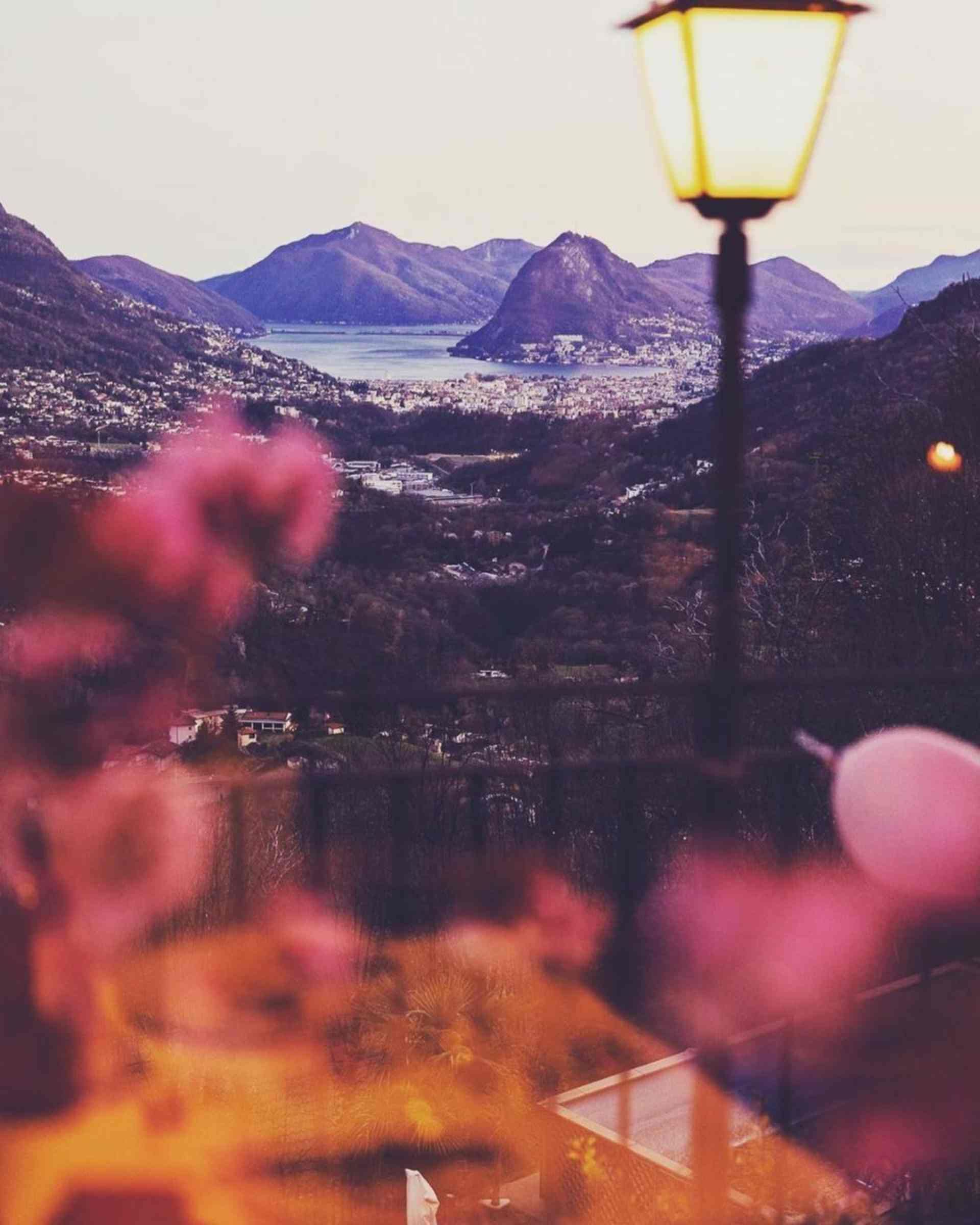 Un lampione con vista su una città e montagne sullo sfondo