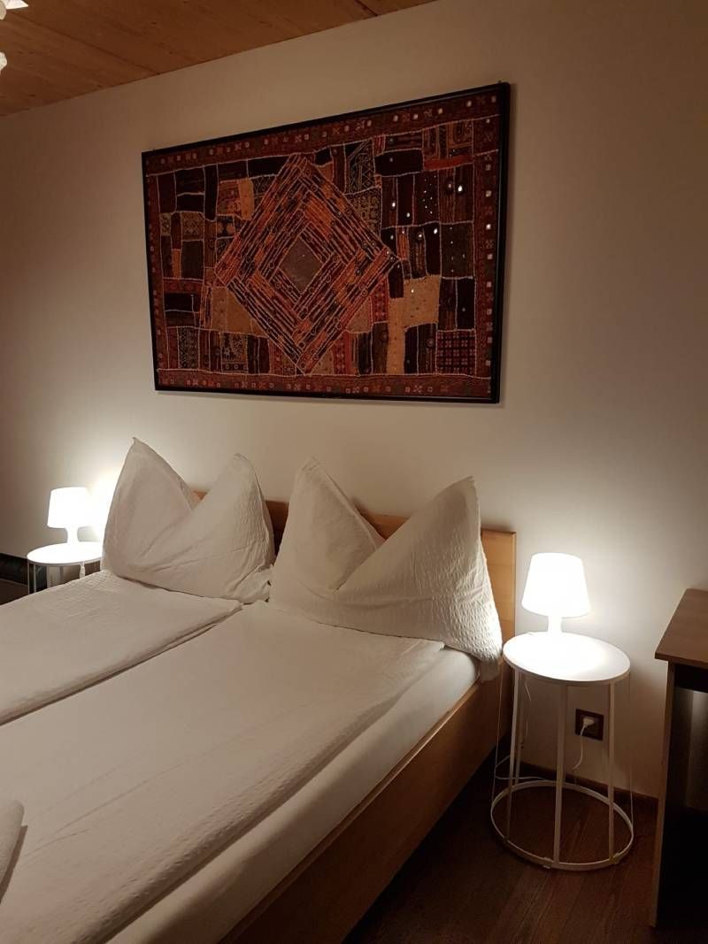 Una camera da letto con un letto, due lampade e un arazzo sulla parete.