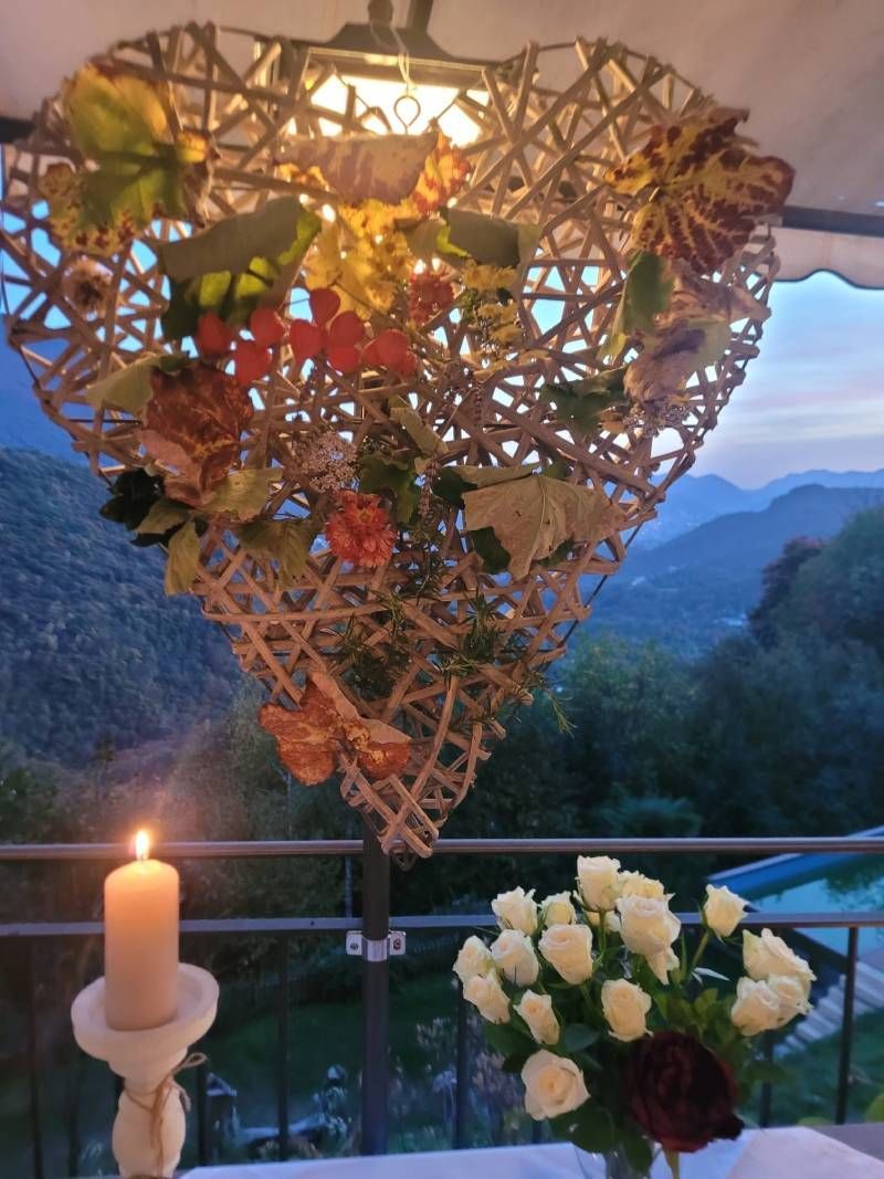 Una candela è accesa davanti a una decorazione a forma di cuore