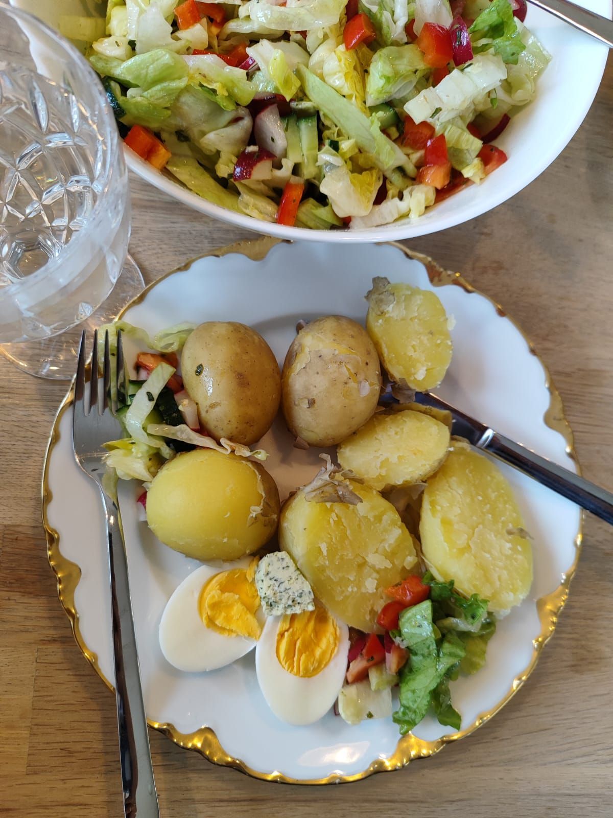 Ein Teller mit Kartoffeln, Eiern und Salat auf einem Tisch