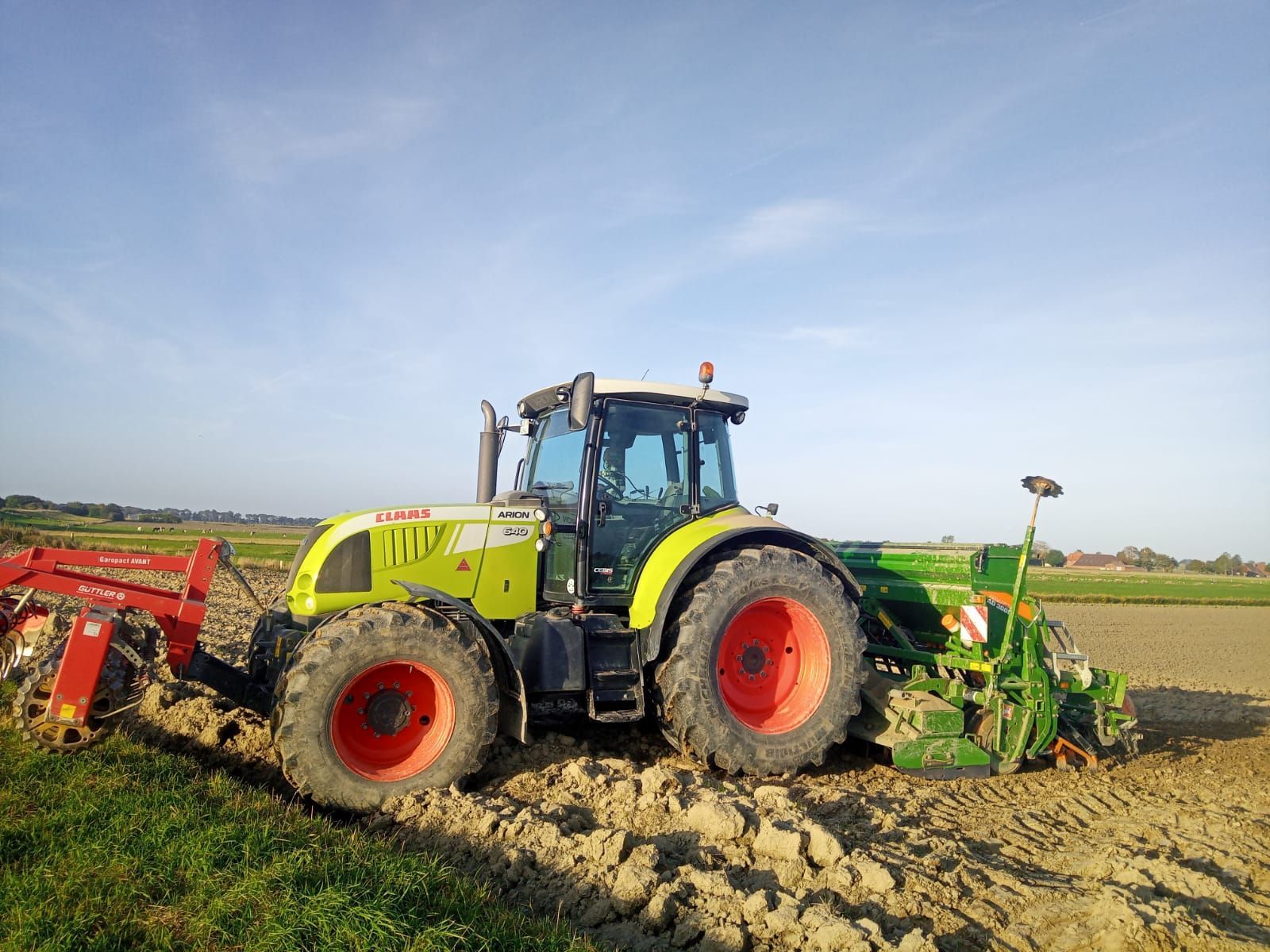 Ein Traktor mit angebautem Pflug pflügt ein Feld.