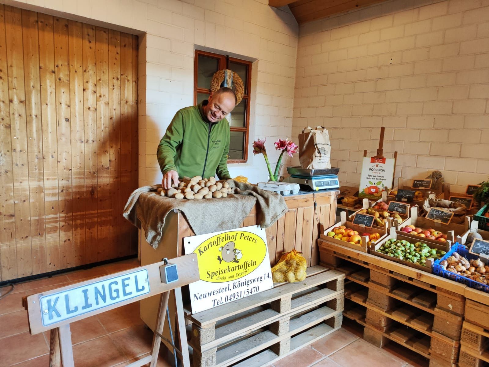 Ein Mann steht vor einem Tisch voller Obst und Gemüse.