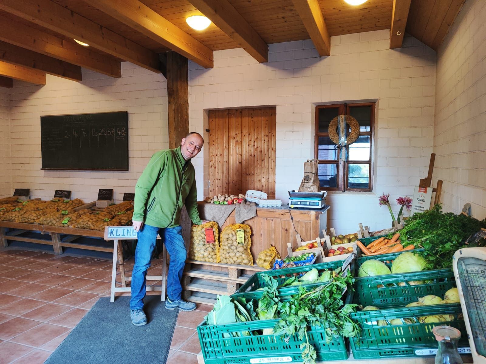 Ein Mann steht vor einer Auslage mit Obst und Gemüse.