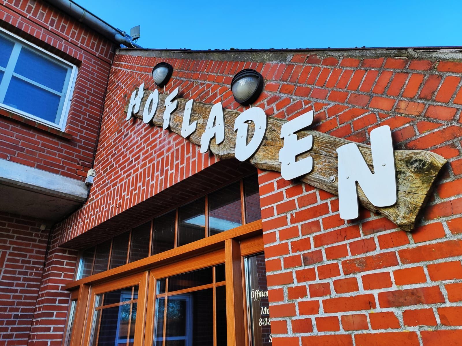 Ein Backsteingebäude mit einem Schild mit der Aufschrift „Hofladen“