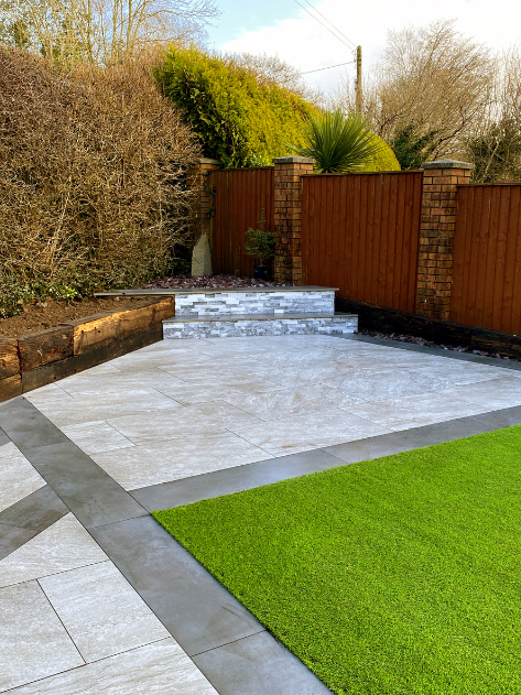 Un patio avec des marches et une clôture en bois dans une cour arrière.