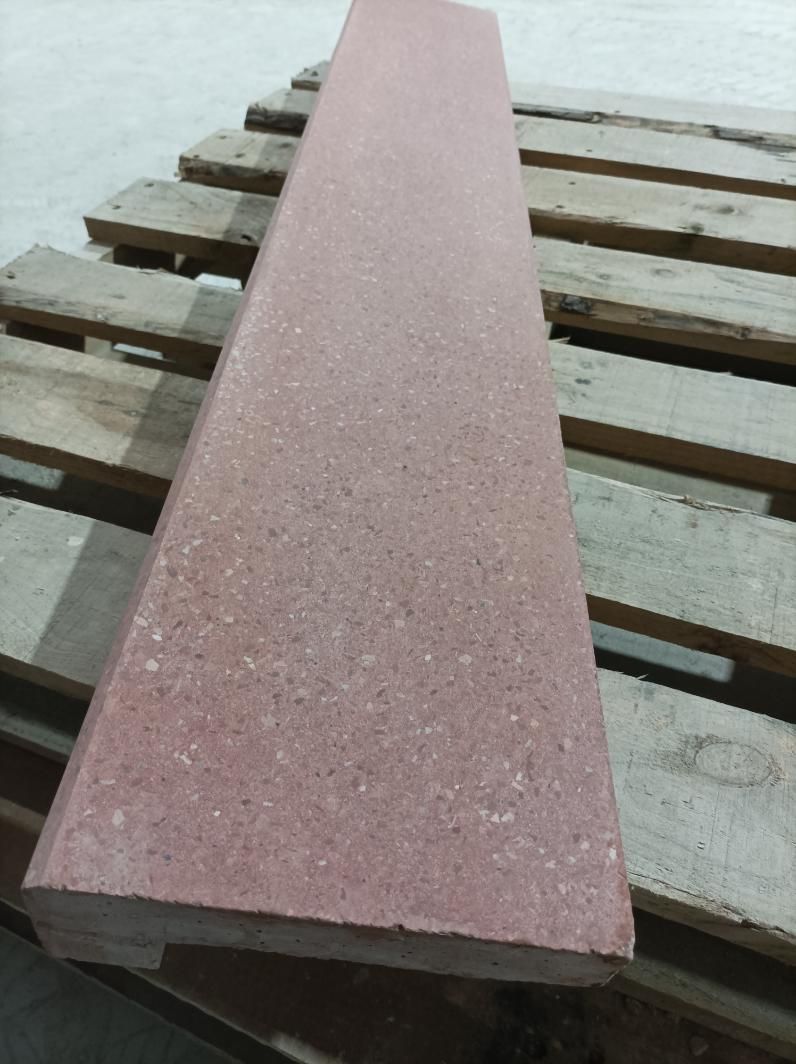 Losa de piedra rectangular de color rojo sobre un palé de madera.