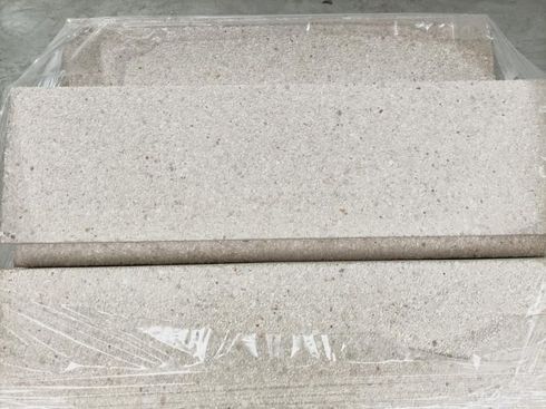 Tres ladrillos rectangulares de color beige envueltos en plástico.