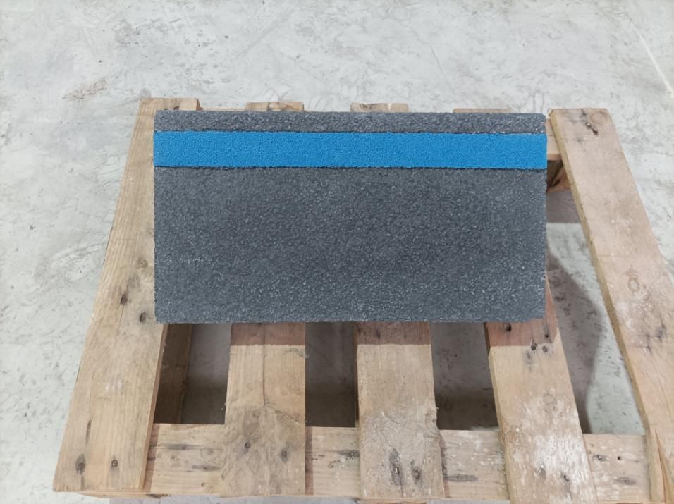 Escalones de hormigón texturizado de tres niveles, de color verde oscuro, sobre una superficie gris claro.