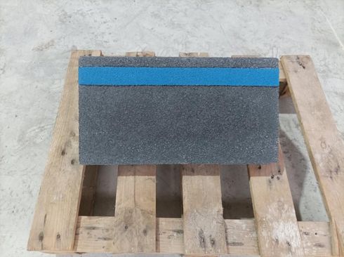 Escalones de hormigón texturizado de tres niveles, de color verde oscuro, sobre una superficie gris claro.