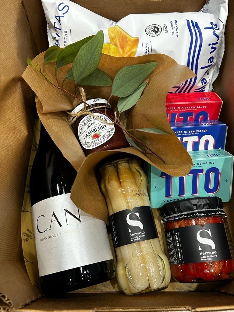 Una caja llena de comida y una botella de vino.