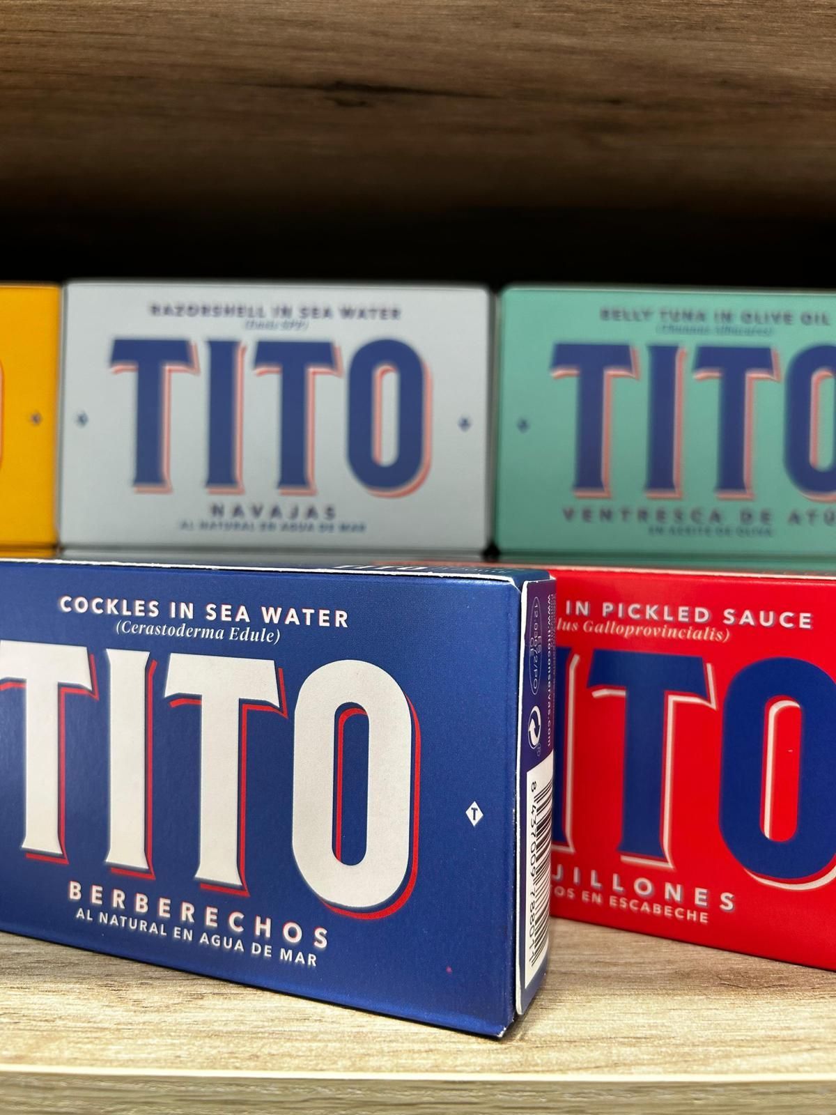 Tres cajas de tito están en un estante de madera.