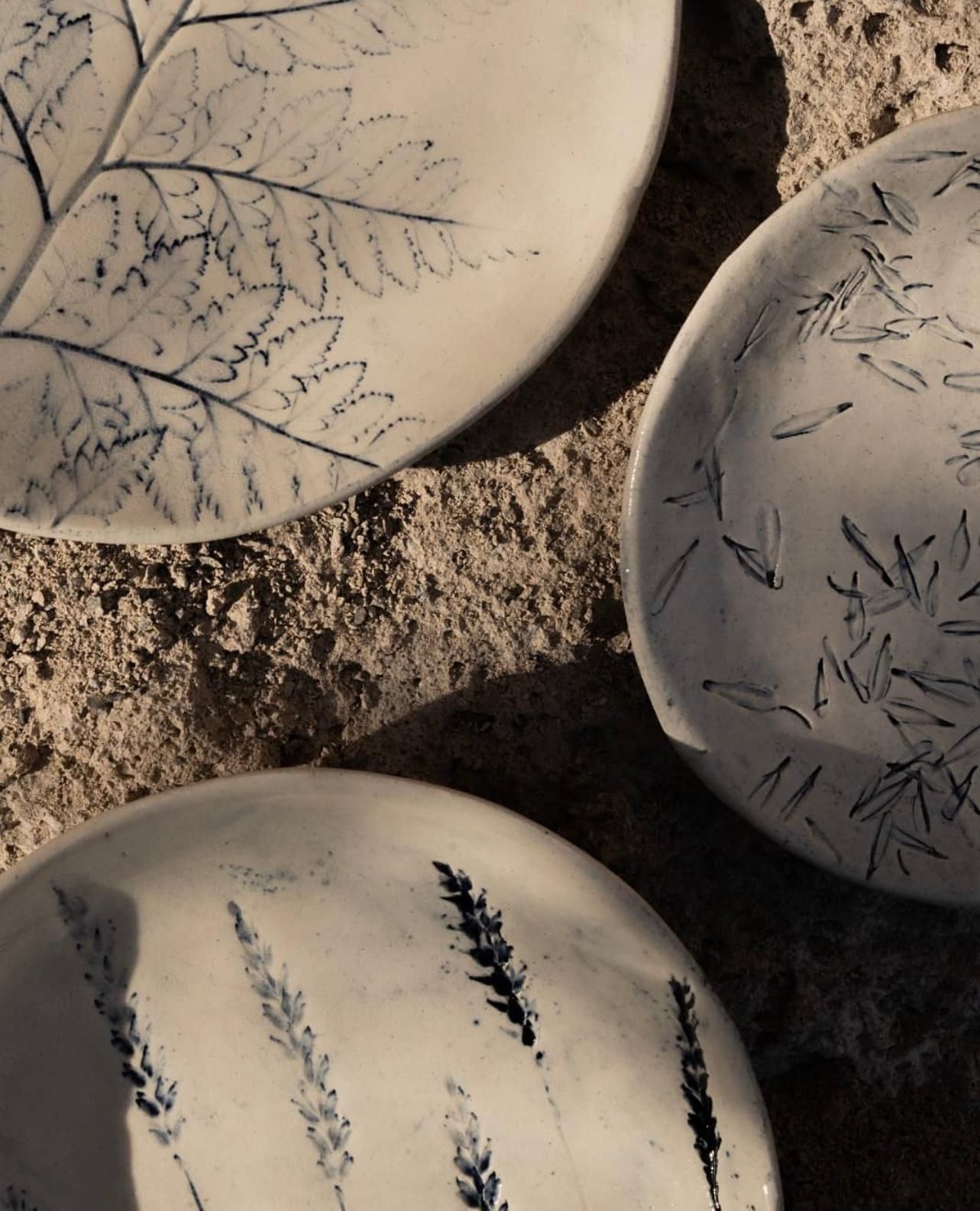 Tres platos blancos con hojas negras sobre ellos