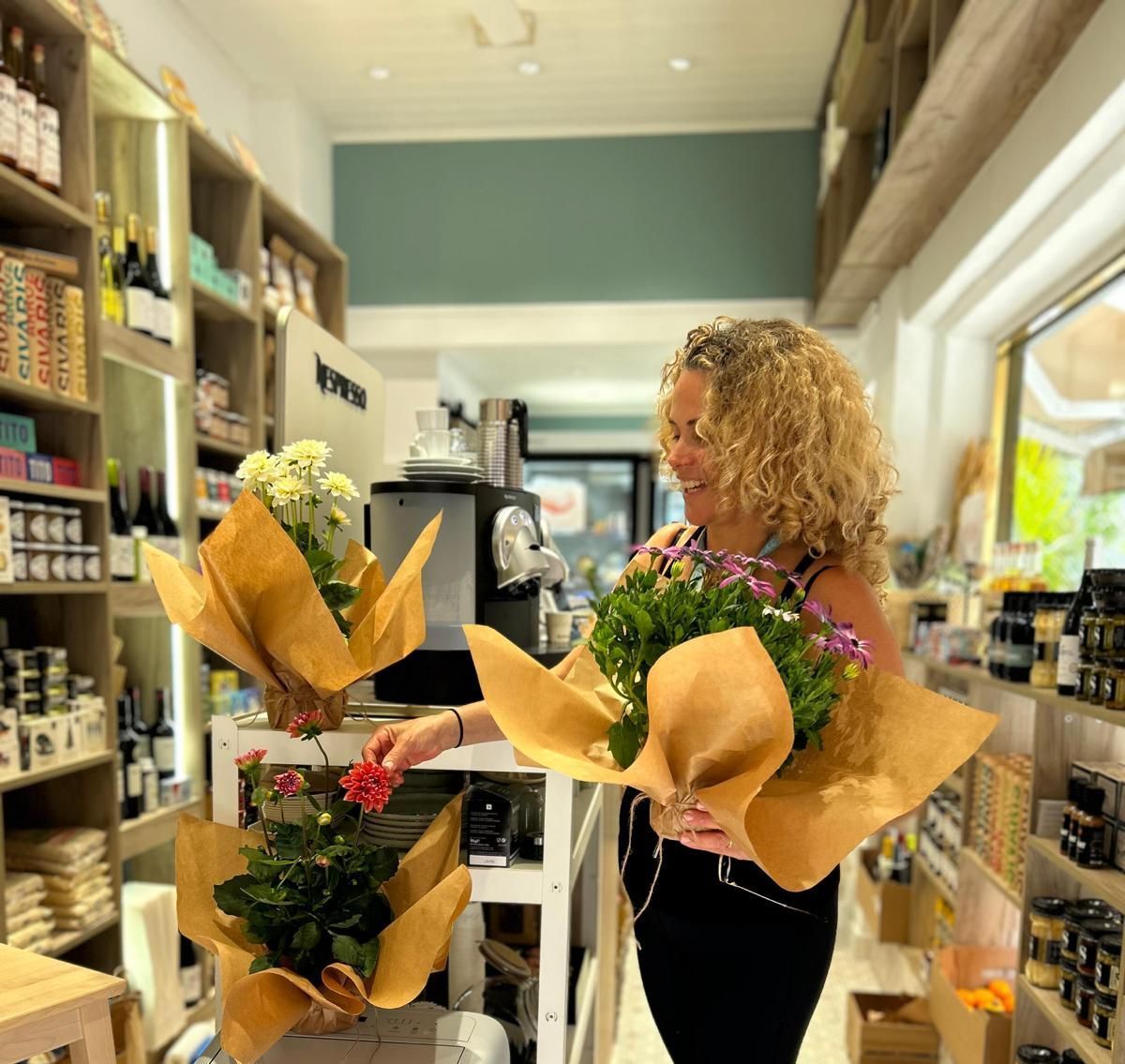 Una mujer sostiene un ramo de flores en una tienda.