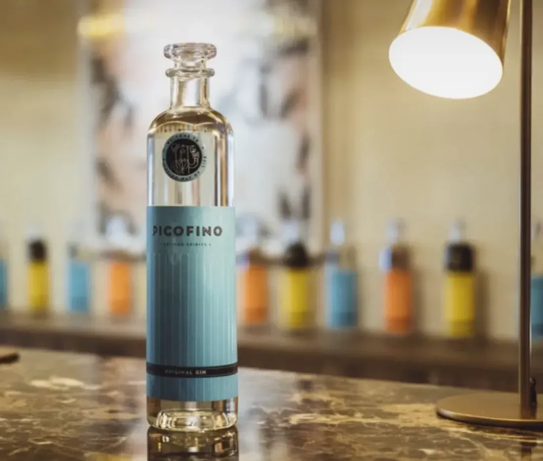 Una botella de nicofino reposa sobre un mostrador junto a una lámpara.