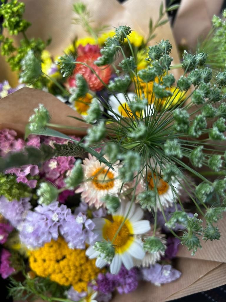 Un primer plano de una persona sosteniendo un ramo de flores.