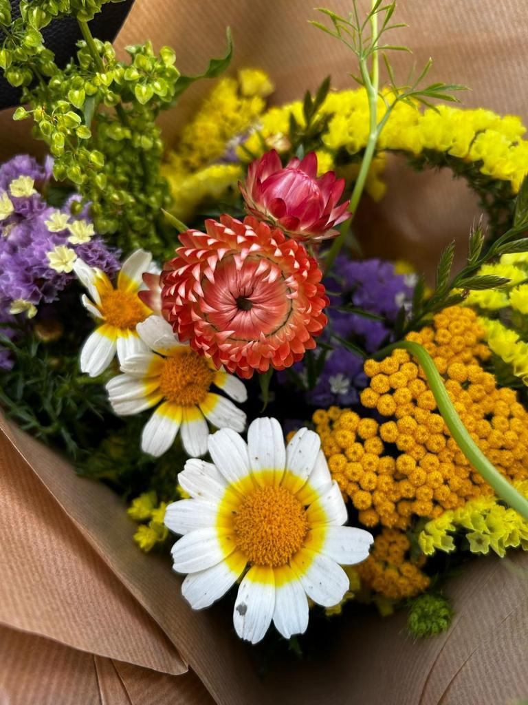 Un primer plano de un ramo de flores envuelto en papel marrón.