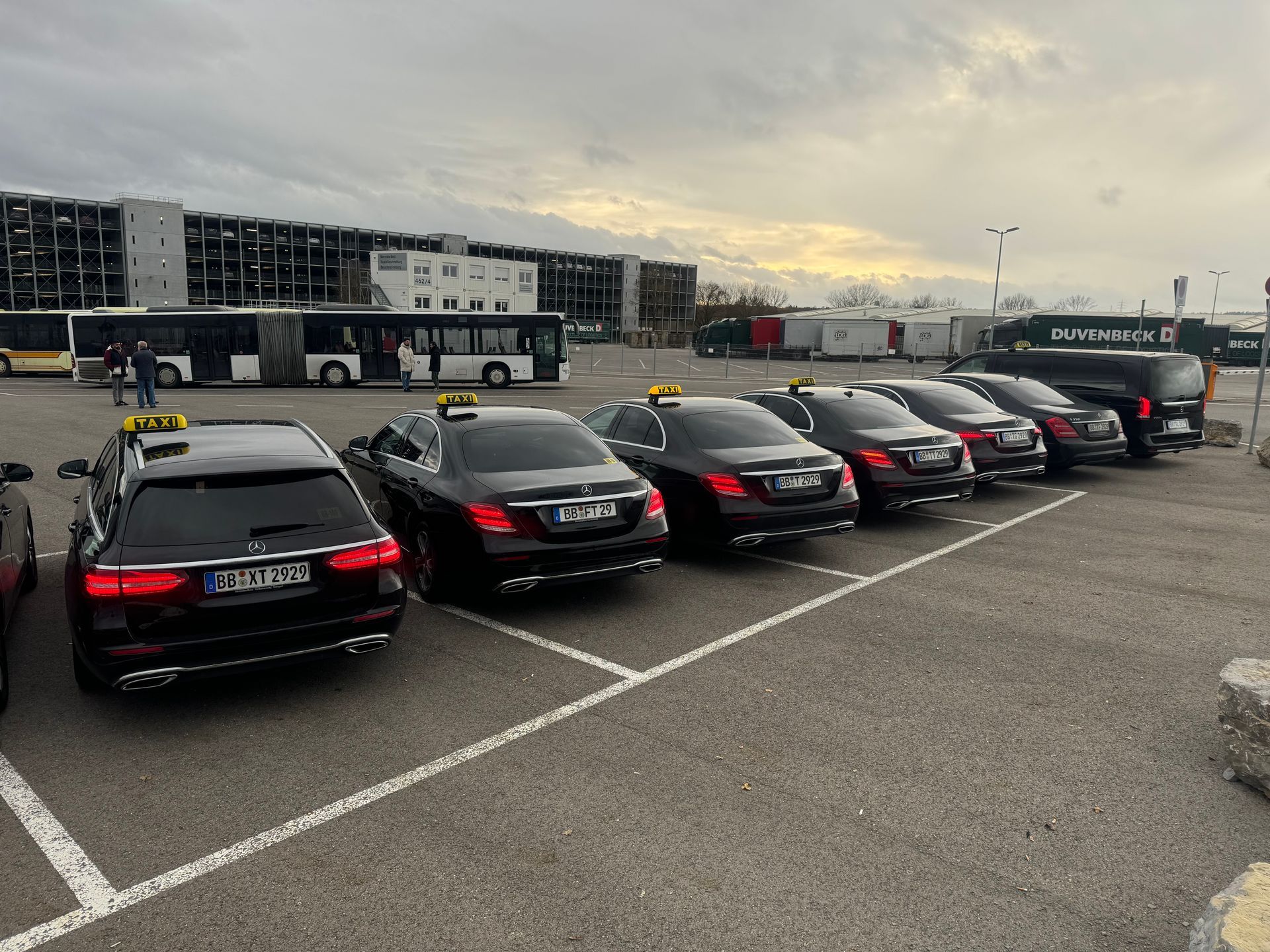 Ein rotes Auto ist am Straßenrand vor einem Berg geparkt.